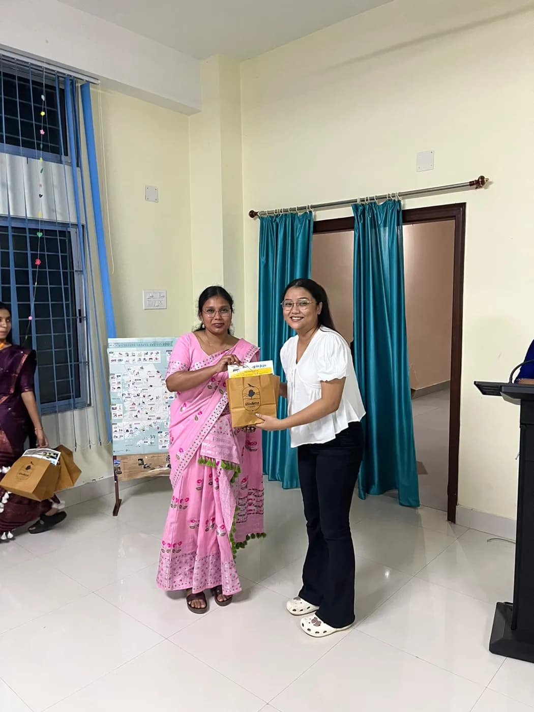 A guest handing over a Windsong Café gift bag to a participant