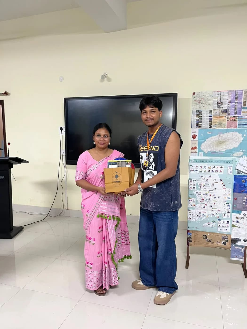 A winner receiving a gift bag with sponsor stickers