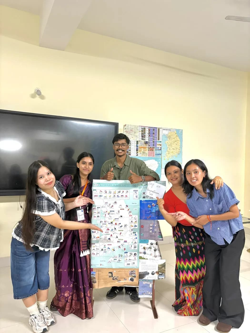 Club members beside the Korea travel map display