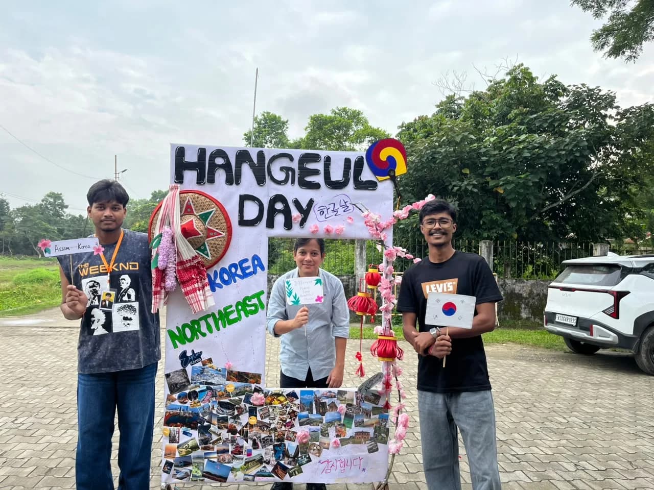 Three members posing in the Hangeul Day photo frame