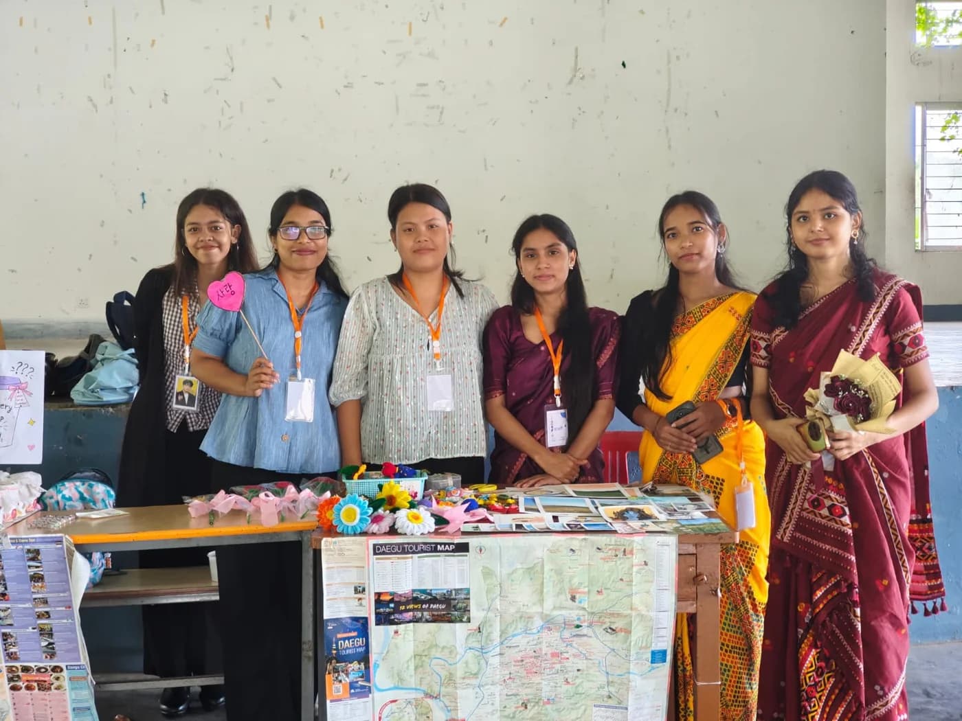 Six students at a stall with a Daegu tourist map and handmade flowers